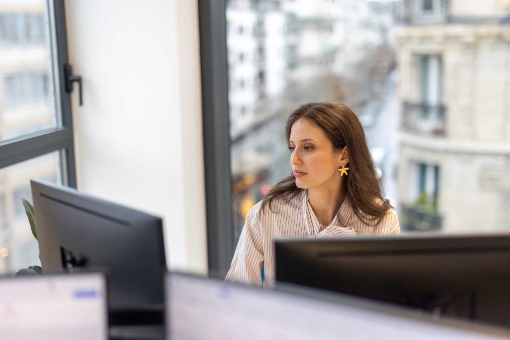 Femme devant 2 écrans d'ordinateur