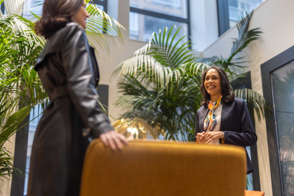 Femme accueil une cliente dans un lobby d'hôtel de luxe